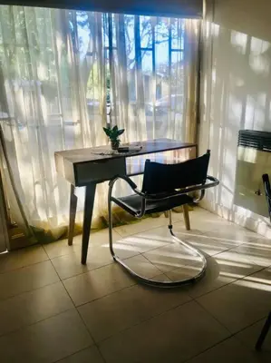 a desk and a chair in front of a window at Cálido Loft con pileta cerca del centro. in Villa Carlos Paz