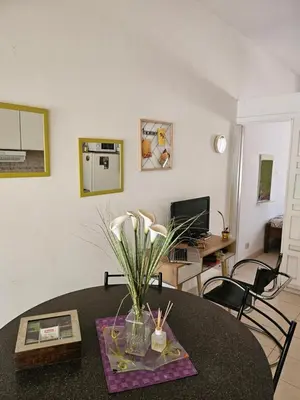 a living room with a table with a vase of flowers at Cálido Loft con pileta cerca del centro. in Villa Carlos Paz