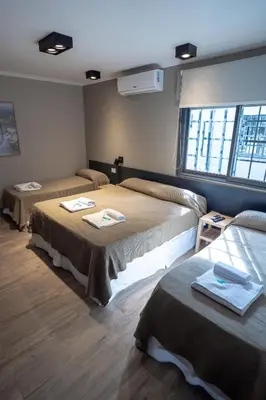 a room with two beds and a window at Nuevo Centro Hotel Villa Carlos Paz in Villa Carlos Paz