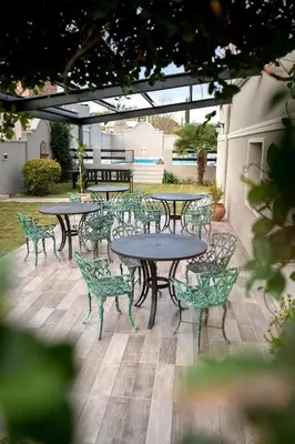 a group of tables and chairs on a patio at Nuevo Centro Hotel Villa Carlos Paz in Villa Carlos Paz