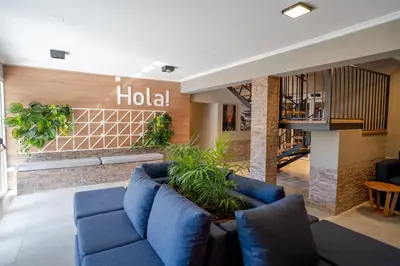 a lobby of a hotel with blue couches and plants at Nuevo Centro Hotel Villa Carlos Paz in Villa Carlos Paz