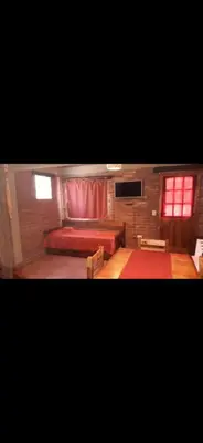 a bedroom with a red bed and a red window at La Quina. in Villa Rumipal
