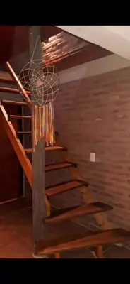 a wooden staircase in a room with a ceiling at La Quina. in Villa Rumipal