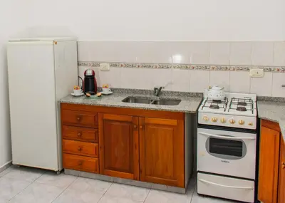 a kitchen with a stove and a sink and a refrigerator at Depto 5 in Villa Carlos Paz
