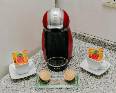 a toaster sitting on a counter with two cups of coffee at Depto 5 in Villa Carlos Paz
