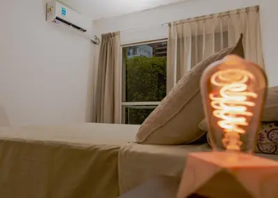 a candle on a table next to a bed at Depto 5 in Villa Carlos Paz