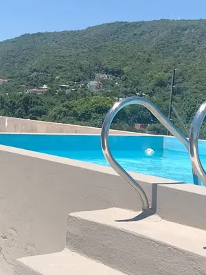 a metal railing next to a swimming pool at Dpto en alquiler temporario en VCPaz in Villa Carlos Paz