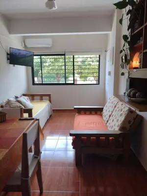 a living room with a couch and a bed in it at Dpto en alquiler temporario en VCPaz in Villa Carlos Paz