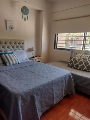 a bedroom with a bed with a blue blanket and a window at Dpto en alquiler temporario en VCPaz in Villa Carlos Paz
