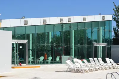 a group of white chairs in front of a building at Departamento Temporario en Alto Villasol in Cordoba