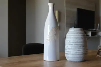two white vases sitting on a wooden table at Departamento Temporario en Alto Villasol in Cordoba