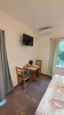 a room with a table and chairs and a tv at Dormis:Lodesilvi in Merlo
