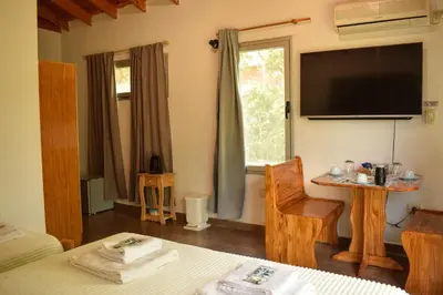 a bedroom with a tv and a bed and a chair at Dormis:Lodesilvi in Merlo