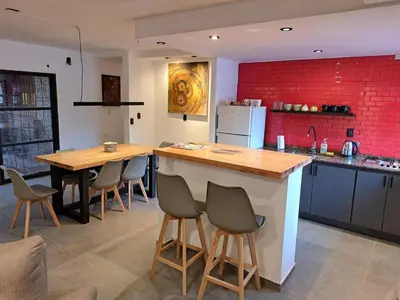 a kitchen with a counter and a table and chairs at Departamento Entero 2 Dormitorios B° Urca con Cochera in Cordoba
