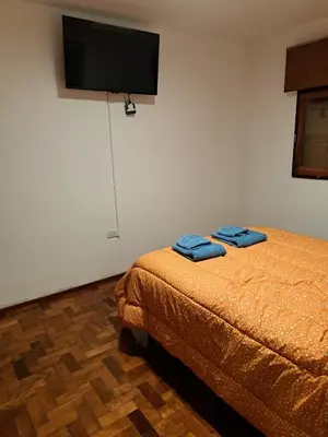 a bedroom with a bed and a flat screen tv at Departamento Entero 2 Dormitorios B° Urca con Cochera in Cordoba