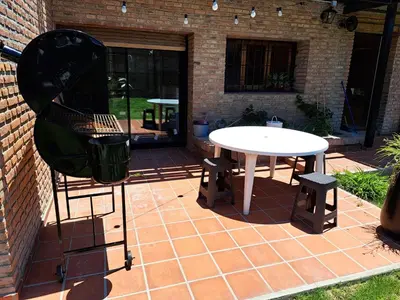 a white table and stool on a brick patio at Departamento Entero 2 Dormitorios B° Urca con Cochera in Cordoba