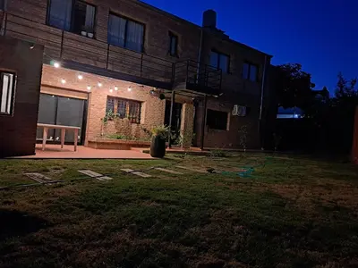 a house with a lawn in front of it at night at Departamento Entero 2 Dormitorios B° Urca con Cochera in Cordoba