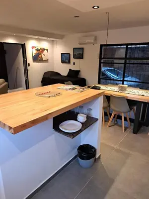 a kitchen with a wooden counter and a table at Departamento Entero 2 Dormitorios B° Urca con Cochera in Cordoba