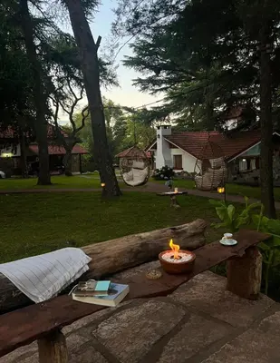 a wooden bench with a candle and books on it at Cabañas Aufenthalt in Villa General Belgrano