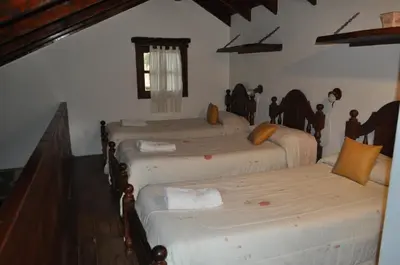 a group of four beds in a room at Cabañas Aufenthalt in Villa General Belgrano