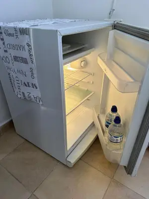 an open refrigerator with two bottles of water in it at AMPLIOS Departamentos PASAJE TUCUMÁN in Alta Gracia