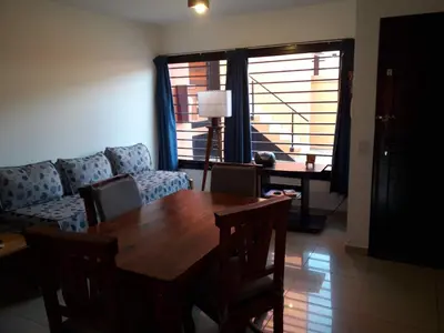 a living room with a wooden table and a couch at Departamento de Caroya in Villa Carlos Paz