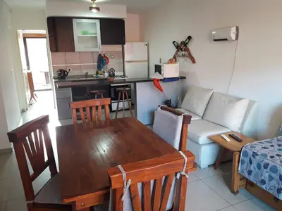 a kitchen and living room with a table and a couch at Departamento de Caroya in Villa Carlos Paz