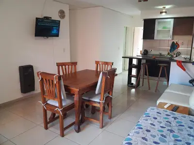 a kitchen and dining room with a wooden table and chairs at Departamento de Caroya in Villa Carlos Paz