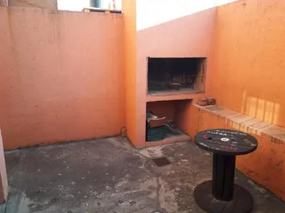 a room with a fireplace with a table in it at Departamento de Caroya in Villa Carlos Paz