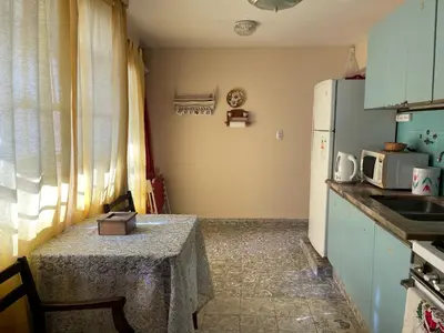 a small kitchen with a table and a refrigerator at Casa Rosa in Alta Gracia