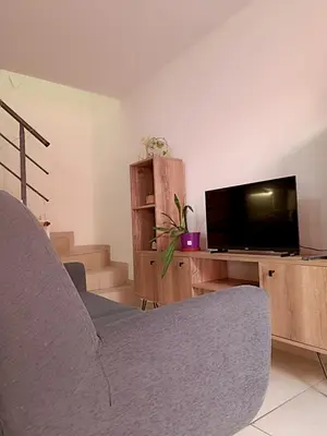 a living room with two chairs and a flat screen tv at La Lunita in Cordoba