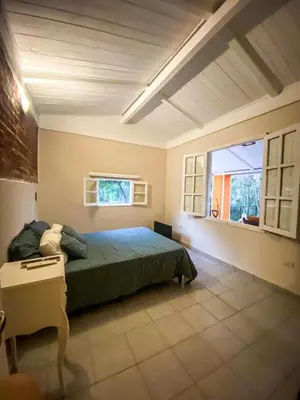 a bedroom with a bed and a desk and a window at Departamento Sofía in Tanti