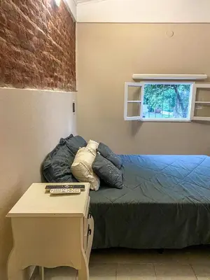 a bedroom with a bed with a table and a window at Departamento Sofía in Tanti