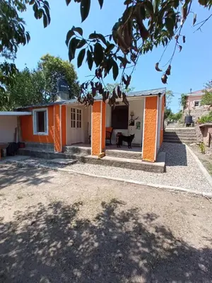 a home with an orange and white house at Departamento Sofía in Tanti
