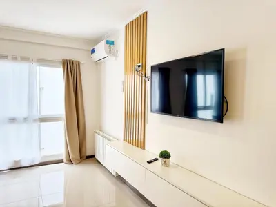 a living room with a flat screen tv on a wall at VENETO V DEPARTAMENTOS in Villa Carlos Paz