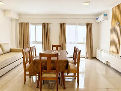 a dining room with a table and chairs and a couch at VENETO V DEPARTAMENTOS in Villa Carlos Paz