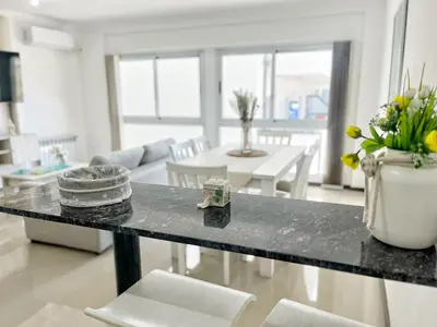 a kitchen and living room with a table and chairs at VENETO V DEPARTAMENTOS in Villa Carlos Paz
