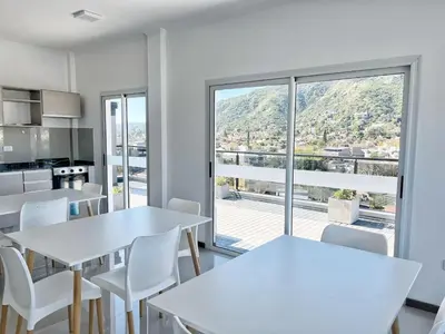 a kitchen with white tables and chairs and a large window at VENETO V DEPARTAMENTOS in Villa Carlos Paz