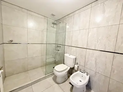 a bathroom with a toilet and a shower and a sink at VENETO V DEPARTAMENTOS in Villa Carlos Paz