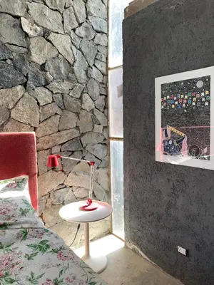 a bedroom with a stone wall and a table next to a bed at Jauja in San Javier