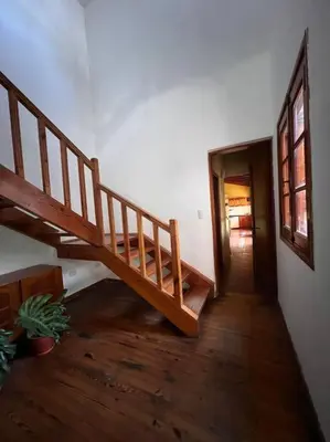 a hallway with a wooden staircase in a house at Hermosa casa en el corazón de Alta Córdoba in Cordoba
