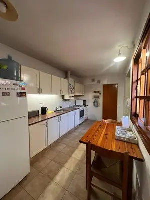 a kitchen with a wooden table and a white refrigerator at Hermosa casa en el corazón de Alta Córdoba in Cordoba