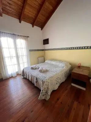 a bedroom with a bed and a wooden floor at Hermosa casa en el corazón de Alta Córdoba in Cordoba