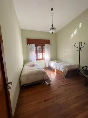 a bedroom with two beds and a wooden floor at Hermosa casa en el corazón de Alta Córdoba in Cordoba