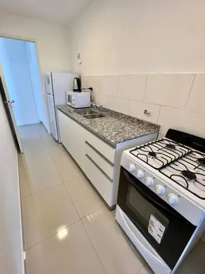 a white kitchen with a stove and a sink at Departamento para dos personas in Cordoba