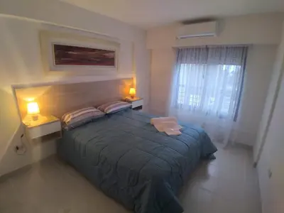 a bedroom with a large bed and two lamps at Güemes apartamento in Cordoba