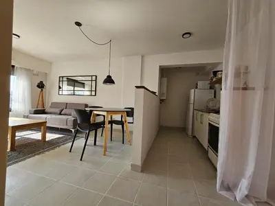 a kitchen and living room with a table and a couch at Güemes apartamento in Cordoba
