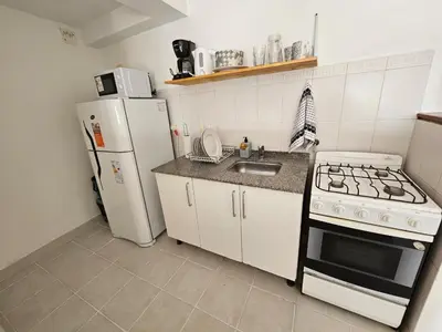 a small kitchen with a stove and a refrigerator at Güemes apartamento in Cordoba