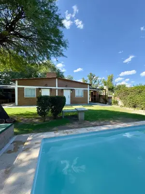 a house with a swimming pool in front of a house at La Algarroba in Alta Gracia