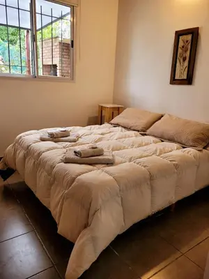 a large bed in a bedroom with towels on it at La Algarroba in Alta Gracia